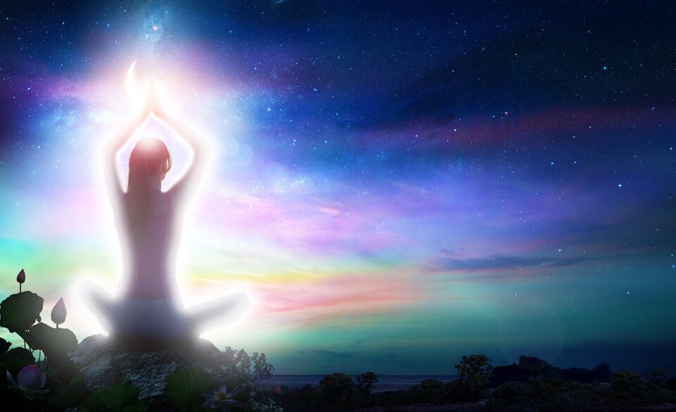 A woman meditates with a white aura